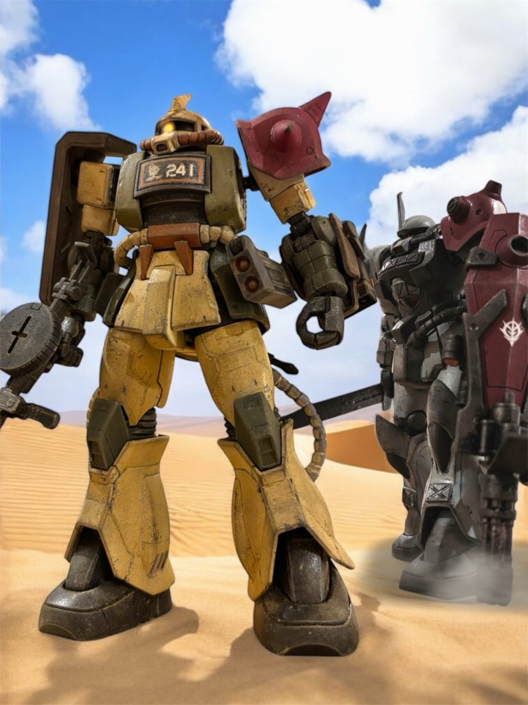 　ジオン公国軍ハリソン・サトー少佐は、左肩が赤く塗られた愛機のザクを荒野に立たせて、３ｋｍ先の渓谷の出口を見つめていた。随伴している僚機はわずか３機だった。『マイロ伍長とイアン曹長が戻りました。９機の１個中隊です。』近づいてきたグフのパイロットが告げる。ブル―グレーの機体は、左肩とそしてシールドも赤く塗られている。「さて、出番だな大尉。」　グフのパイロットは、アーサー・クレイグ大尉。マ・クベ大佐の指揮下でオデッサ鉱山地帯の前線拠点を指揮していたが、連邦軍の物量戦に敗れ、アフリカ戦線まで流れてきたのだ。共にオデッサを脱出してきた、部下のマイロ伍長とイアン曹長を、上空からの偵察に向かわせていた。「”オデッサのガンダム殺し”、お手並みを見せてもらうぞ。」アーサー大尉の報告に応じるハリソン少佐の声は快活だ。『……およしください。たった１機を落とすのに、２機も失いました。』「謙遜するな大尉。さあ、いらっしゃったぞ、お客様だ！」　３ｋｍ先の渓谷から、ぬっと、紅白カラーのＭＳが現れた。連邦軍の量産型らしい。のっぺらぼうのような顔に、妙につるんとして起伏のない装甲が、軟弱な印象を持たせる。棺桶のような形の巨大な盾を持っているものもいる。「ご丁寧に、自分が入る棺桶を担いできたらしい！各機、盛大に