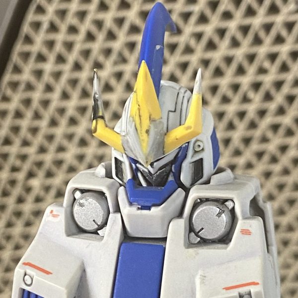原作アニメepisode2劇中にてデキム艦隊に迫るトールギスIIIの顔面アップ。メチャカッコいいんですけど、実は設定とは形状が異なっているようで。(マスクの段差表現なんかが顕著)設定を正解とするならアニメの形状は間違っているのですが、やっぱりこの顔が欲しいよね、という事で再現に挑戦。マスクはフレームを拝借したティガの額部分を切り出し整形、被せるように接着。ツノの付き位置を下方へ移設。写真は折れたキットのツノを補修していますが、削る先からポキポキ折れてどうしようもなかったので、この後MSアンテナのパーツを使って作り直しました。側頭部を削り広がりを抑えました。削って潰れた青いダクトのディテールは掘り直しています。カメラアイ中央に溝を掘り込み。パーツが細かくて整形がかなり大変。サフったら粗が出てきそうですが、取り敢えずあんときのギスIIIに寄せられたかな？（1枚目）