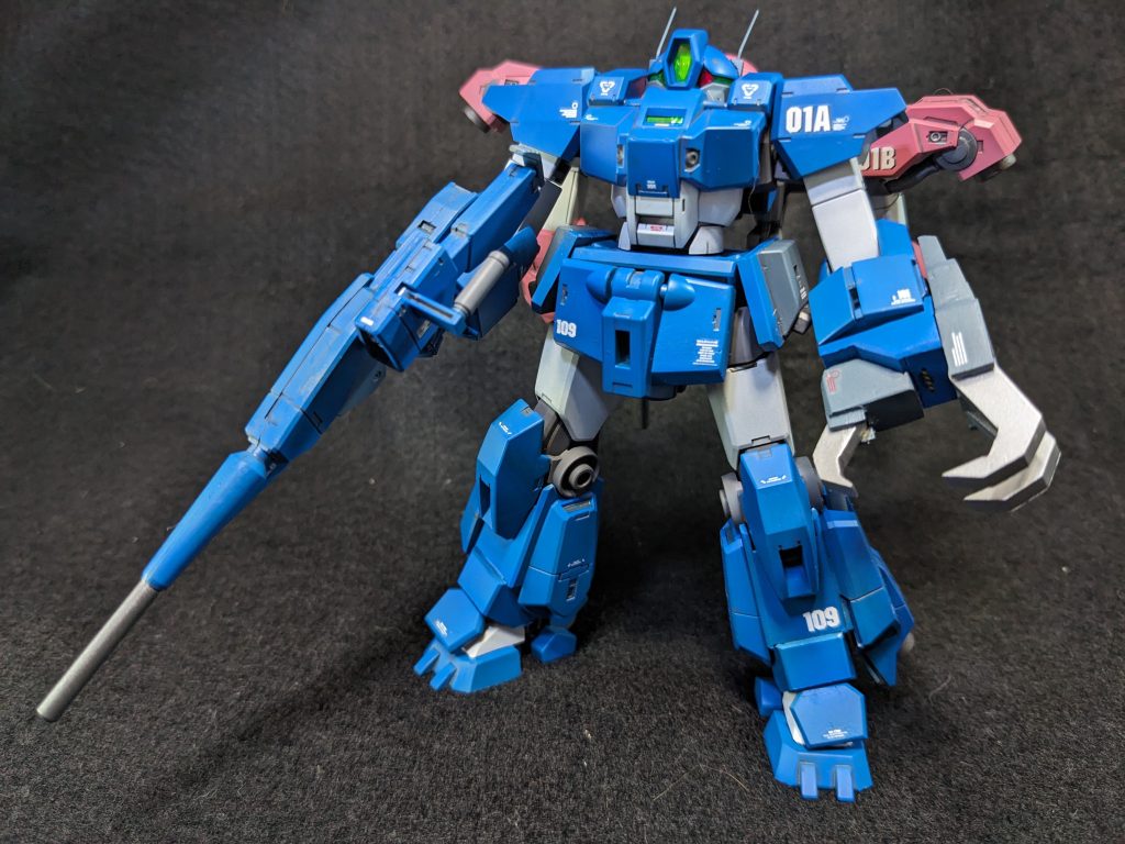  改装ポイントは機動力の向上とオールラウンドでの戦闘継続能力です。　脚部、腰部、背部にスラスターを増設して機動性を上げています。　武装は左腕のクローが特徴で、ＭＳの装甲を引き裂くだけのパワーが有ります。更にクローの間にビーム砲が内蔵されており固定武装の強化もされています。このクローユニットは取り外す事も可能です。　右腕は手の平が通常の３本指ではなく、汎用性の高い５本指と交換しています。　脚部はローラーダッシュを多用する為、強化がされました。改修予定だったデミトレーナーのパーツを使ってスラスターの強化がされてます。　肩のスラスターユニットは格闘戦の邪魔になると判断して排除。動きを阻害しない軽い物に交換してます。　頭部には通信能力を強化したロッドアンテナが２本装備しました。　キリコ先輩は武器に拘りが無い為、ライフルは既存の物を使用しています。