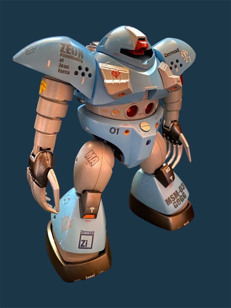 MSM-03ゴッグはジオン公国軍の量産型水陸両用MSである。開発はドムなどを手がけたツィマッド社によって行われた。ジオン独立戦争中に地球攻撃軍において本格的な水陸両用機として制式配備され、潜水艦隊の戦力として公国軍の海洋戦略を支えた。戦後も地球連邦軍残党の討伐に重宝される一方で、深海での作戦にも耐えうる耐圧殻の堅牢性や、水中における行動可能時間の長さから、救助隊のMSとして特殊装備を追加した機体が配備されている。