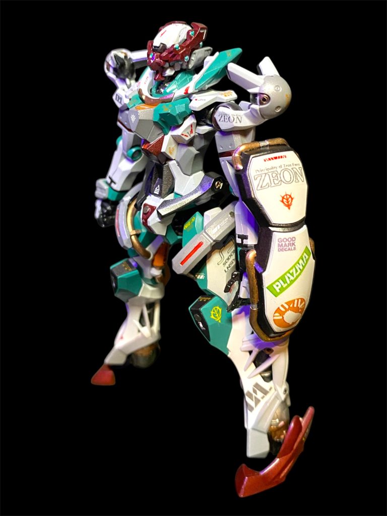 「ジーーーークアクス！！」地球に降りて以来、久々に愛機との再会を果たしたマチュの表情はイキイキとしている。「あれ？この色味、、、どこかで見たような？あーー！！！バリ女の制服！」 「情報統制もされてはいますが、エンディミンユニットの覚醒が確認されたイオマグヌッソの一件以来、あなたと同じくジークアクスもあちこちから狙われる身です。ですので、今は民間企業を隠れ蓑にクランバトルに参加している体で我々も活動をしていますが、いささか資金が乏しい。アマテさんの無事を知ったご学友たちから有志でのご寄付も頂きましたが、何分、名門校の名前を非合法競技に参加する機体に入れる訳にもいきませんので…せめて、ハイバリー女学院のスクールカラーでリスペクトを。という、コモリ中尉発案の図らいです。」「センスあるじゃーん、コモリン♪」