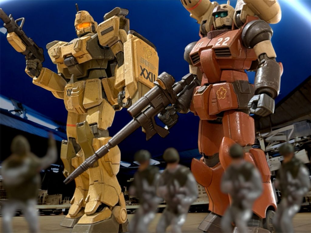 「22部隊、ガンダムとキャノンを出すぞ。」外部スピーカーで、ハンガー内に呼びかけると、ズシン、と機体を踏み出させる。ゲートを潜って外に出ると、東の空にちかちかと閃光が走るのが見えた。 ダマスカスの東には、メガ粒子砲を含んだ対空砲が設置され、防衛線が敷かれている。敵の部隊はそこを突破できずにいるのだろう。『少尉、東の防衛線の位置は分かっているな。』 ブライトマンから通信が入った。『航空戦力は、対空砲で防げそうだが、MSも連れてきている。例の砂に潜れるやつだ、ちょっと見てきてくれるか。』 防衛ラインにもMS隊は配備されている。ブライトマンの口ぶりから、苦戦しているわけではなさそうだ。 了解、と返事をすると、ミヤギのガンキャノンに直通で通信を送る。「つまりは、威力偵察だ。曹長、無理はするなよ。」いつものような歯切れがない、はあ、という声が帰ってくる。別に、先ほどのブライトマンとのやり取りを意識したわけではないが、つい、ミヤギを気遣うようなことを付け加えたのが、怪訝に感じさせたらしい。「すまない、行くぞ。」会話の上では、脈絡のない謝罪だが、戦闘が始まっている今、二人とも気にする余裕などない。2機は、東の戦火を目指して駆けだした。■■■■■■■■■■■■■■■