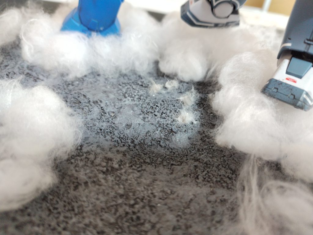 地面は、作品を見返しながら作りました。土台はスタイロフォーム足跡はエポキシパテに脚を押し付けて、作成作品では、爆風による煙が大量に舞っていたので、綿でそれを表現しました。…綿はグレーで塗りたかったのですが、何度か試してうまく出来ない為、そのまま使いました。