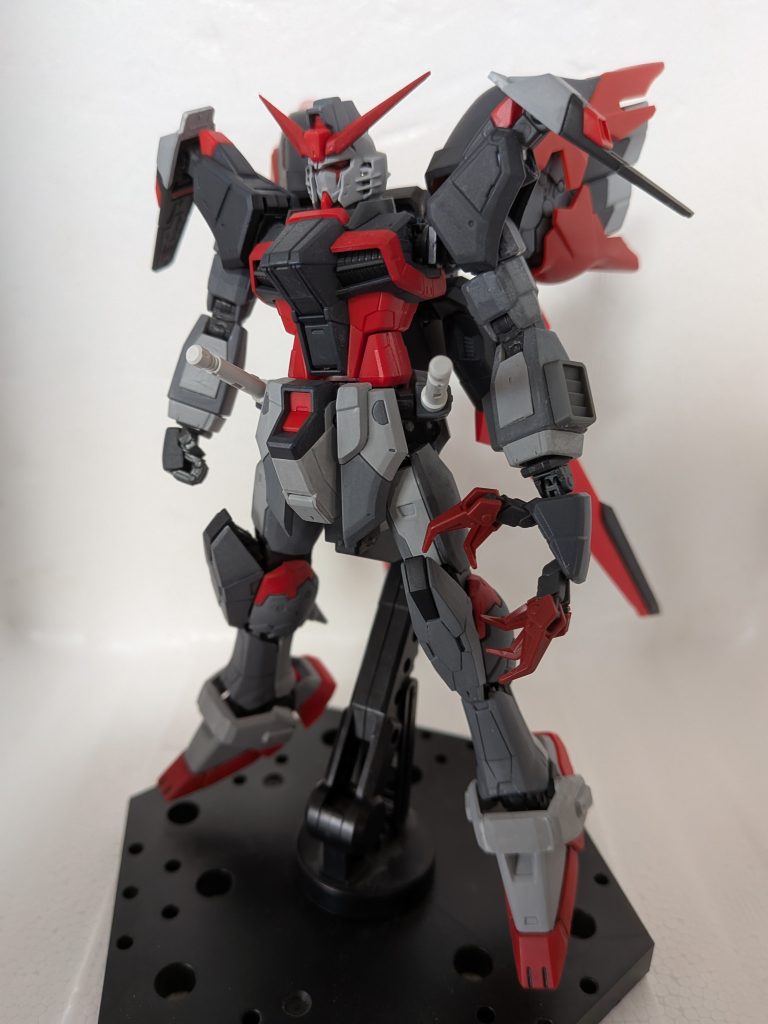 機体色は上記のイラストを尊重して黒にしていますが、私の記憶ではFREEDOM放映前まではVPS装甲は黒が最も電力消費が低いという設定があったような覚えがあります。それを踏まえ、キットには特に手を加えてはいませんが核エンジンへの負荷を減らすためにVPS装甲への電力供給用にインパルスのバッテリーを移植し、さらに電力消費の少ない黒い装甲で運用している、という設定を生やしました。両肩はフラッシュエッジ2を取り外してRGガンダムMk-IIの腰のAMSジョイントを組み込み、回転軸を仕込んでデスティニーのサイドスカートを移植しました。元々スラスター的な機能を持っていた節がありますが、レジスタンスが出力を強化して急接近・離脱・方向転換に利用可能な装備に仕上げた、という脳内設定です。イメージ的にはアーマードコア過去作のバックブースター、ターンブースター、マルチブースターを合体させたような感じです。空いた両腰にはRGフォースシルエットの下部ウイングをボールジョイントごと移植する予定でしたが、強度と足の可動範囲に問題があったので急遽ビームサーベルを装着部ごとポン付けしました。レジスタンスの技術者はロストした場合の予備を含めて2基装備させましたが、シンは普段使い用として左腰の物を順手で、緊急時や超接近時の即応用に右腰の物を逆手で使っています。右手しかビームサーベルを握れないので、ビートたけし氏の座頭市のように状況によって使い分ける(狭い場所やほぼ密着した間合いでは順手抜きは向かない等)イメージです。