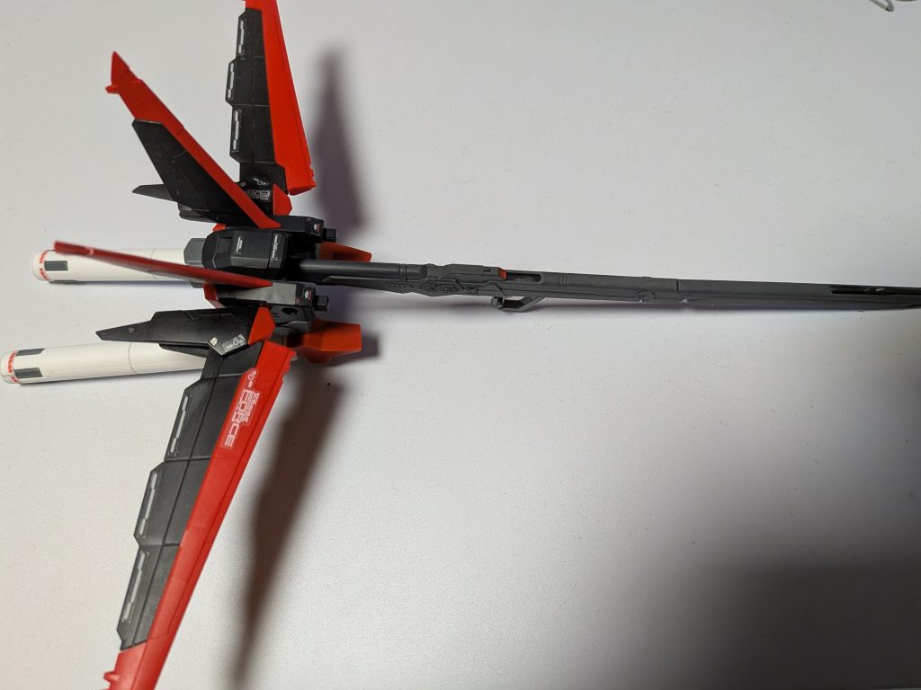 オマケで作ったオプション装備です。見たままですね。名無し砲にフォースシルエットとビームライフルのグリップ、シナンジュのプロペラントタンクを接着しました。設定では高エネルギー長射程ビーム砲の折り畳み機構をオミットして内部構造をブラッシュアップしつつ強度を確保した1発きりの戦術兵器です。シルエット稼働用のエネルギータンクとビーム発射用のエネルギータンクが併設されていて、出撃後に敵艦や敵陣に1発ブチ込んでから放棄されますが、自動帰還プログラムで飛翔して自陣に帰還します。なお、どう頑張ってもケツのシルエットがデカ過ぎて構えられないので、妄想を形にしただけのガチのオマケです。