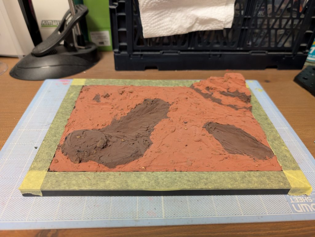 カラーボードのベースをフォトフレームにはめ込み、2色のジオラマ粘土で表面を形成したあと全体に情景テクスチャを塗ってジオラマ完成。今回使用したジオラマ粘土は乾燥時の収縮があるので、カラーボードが若干反りました。大きいボードに塗ると反りを直すのに苦労するかも。