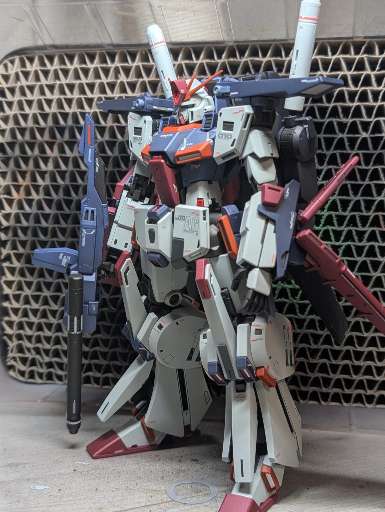 水性ホビーカラーを使用してます。ホワイトのパーツはややグリーンがかったカラーに塗装しました。　ブルー部分は一部濃色と淡色で色分け。ハイメガキャノンも色分けしてます。全体的に元キットのカラーよりトーンを落として塗装しました。 いやーよく見るとエッジ部分に塗料が溜まっちゃってます。希釈難しい ...知らないうちに付着するホコリと塗料カスで萎えますが、部屋に飾って引きで楽しむ分には格好いいので良しとします^^;