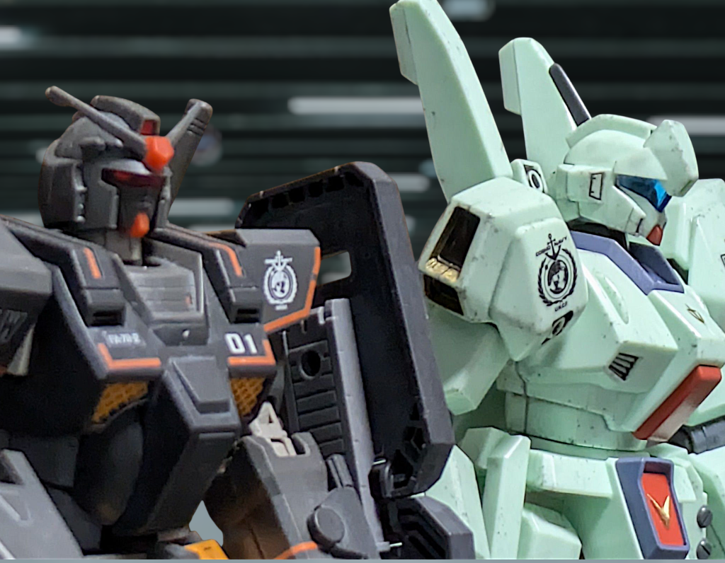 ドゥー[だーかーらー!ヘビーガンダムなんて重苦しくてこれからの時代にそぐわない時代遅れ!これからは身軽な高機動機の時代だとボクは思うわけよ!]シンディ[へぇ～。それならさっきの模擬戦ではその重苦しい時代遅れに撃破判定食らったのはどこの誰かな～?]ドゥー[ムキー💢]コモリがハンガーに着くとヘビーガンダムのパイロットのシンディ・アイケルバーガー少佐とジェガンJ型のパイロットのドゥー・ブル大尉がいつもの様に言い争いになっていたが、低身長のドゥーが高身長のシンディの相手になるわけもなく、まるで子供をおちょくる大人のような構図となっていた。コモリ[またやってる…。アイケルバーガー少佐!ブル大尉!司令から命令書ですよ!!]コモリからの呼びかけで一時休戦となった2人はそれぞれ命令書を受け取ると、互いの顔を見合わせた。シンディ&ドゥー[[コイツと出るの?]]心底嫌そうな顔だった。コモリ[はい。今回エグザべ少尉は留守番で少佐と大尉にクアックス回収に向かってもらうとの事です]ドゥー[ふぅ〜ん…。マチュ見つかったんだ。生きてる?]コモリ[はい。ラサ北部で海兵隊に保護されてます]という事で画像を見せると…。ドゥー[なにこれ(笑)まるで捕獲されたエイリアンじゃん!!]シンディ[確かにそうだな(笑)]コモリ[そういう事なのでお願いします。現地では国連独立コマンド(国連が雇ったPMC部隊)のヘクター・ハモンド中尉の指示に従うようにとの事です]シンディ[まさかヘクターが現地責任者とはな。出世したなアイツ。了解コモリ少尉。ところでジークアクスで一緒に来たニャアンにはマチュの無事伝えたかい?]コモリ[これからですが…]シンディ[そういうのは早く伝えてやりな。あの子の友達なんだから心配してるだろ。そういう所にも気を使わないといけないぞ