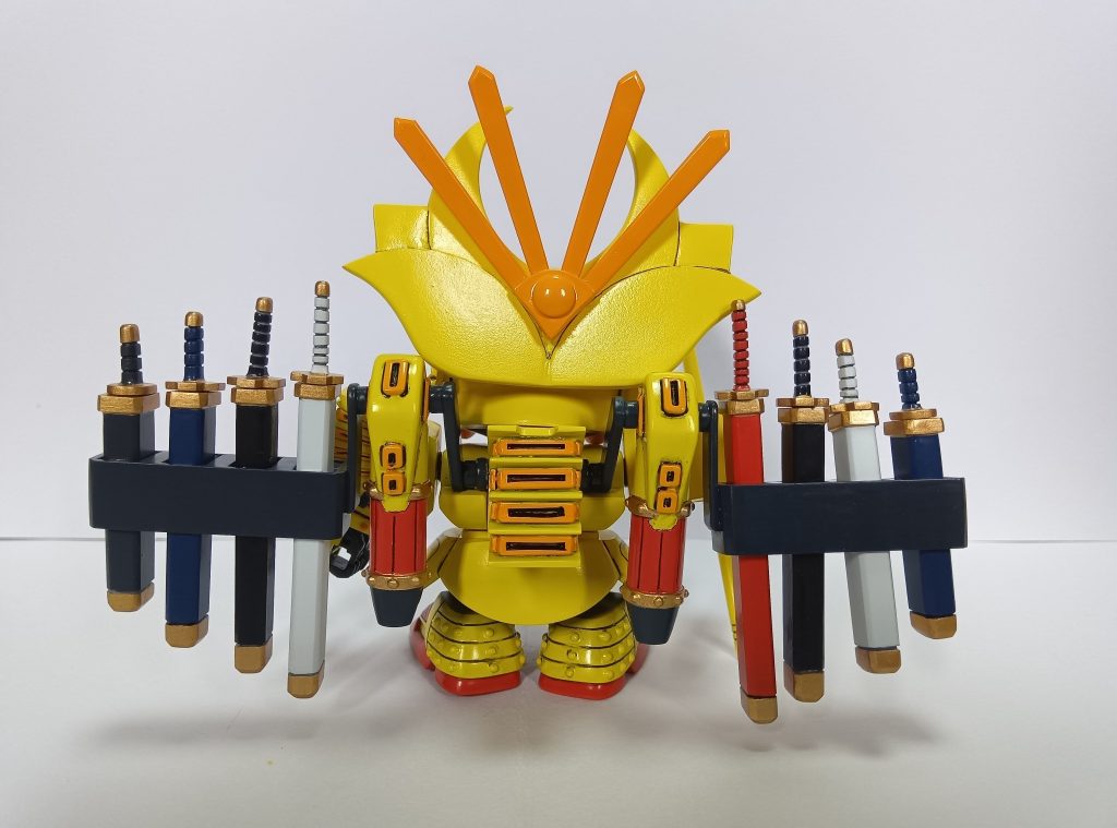 千生将軍は漫画「超戦士ガンダム野郎」に登場するガンプラで、SDガンダムの生みの親、横井孝二画伯がデザインしたガンダムF91の武者バージョンで、主人公・天地大河専用として作られましたが、大河が大福将軍でガンキラー戦で負傷したため杉本ヒロシに託されました。SDスピリット指数は250。