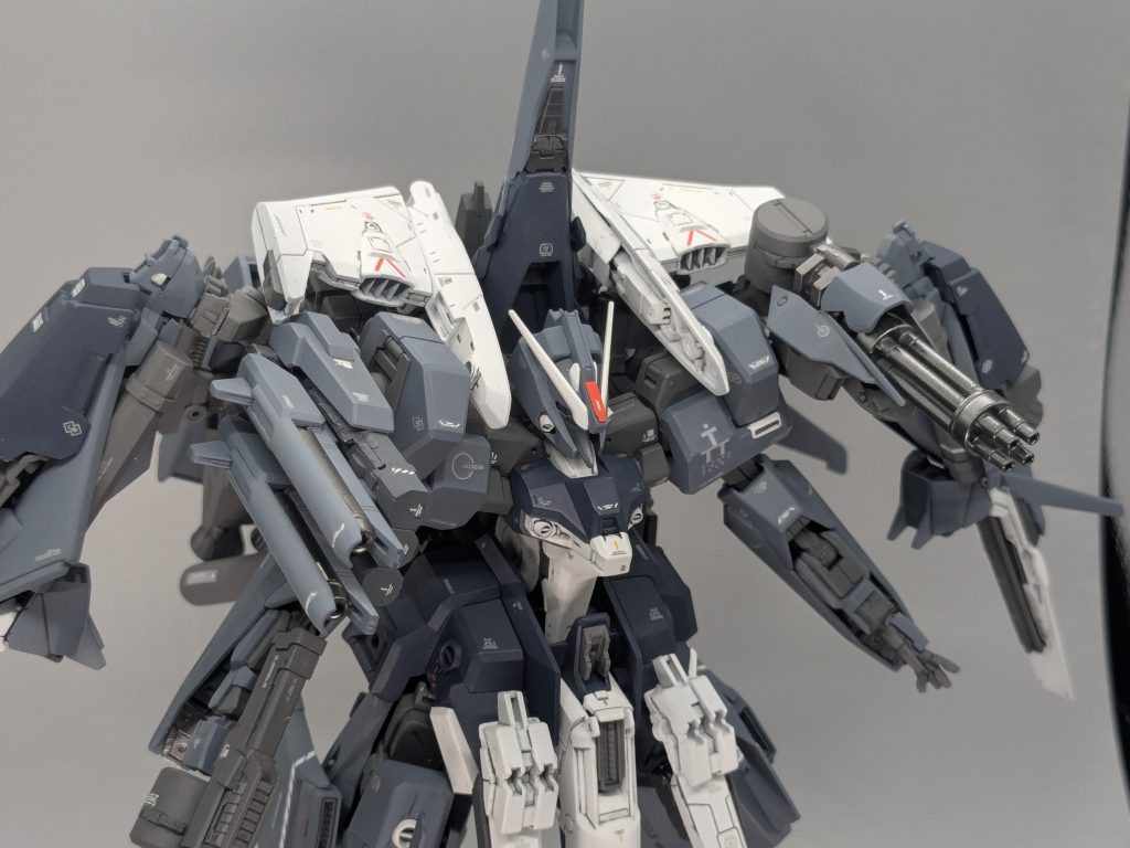 なので両肩裏側には隠し武器っぽく、ドチャクソ盛ります。右肩には付属のビームガンをまとめた装備、左肩にはコアファイターを元にガトリングを装備。手持ち武器で使ったガトリングユニットの砲身を幅詰めし、半分こしたタンクをドラムマガジンに見立てています。それぞれ元の肩裏側のパーツにM.S.Gジョイントで接続しています。