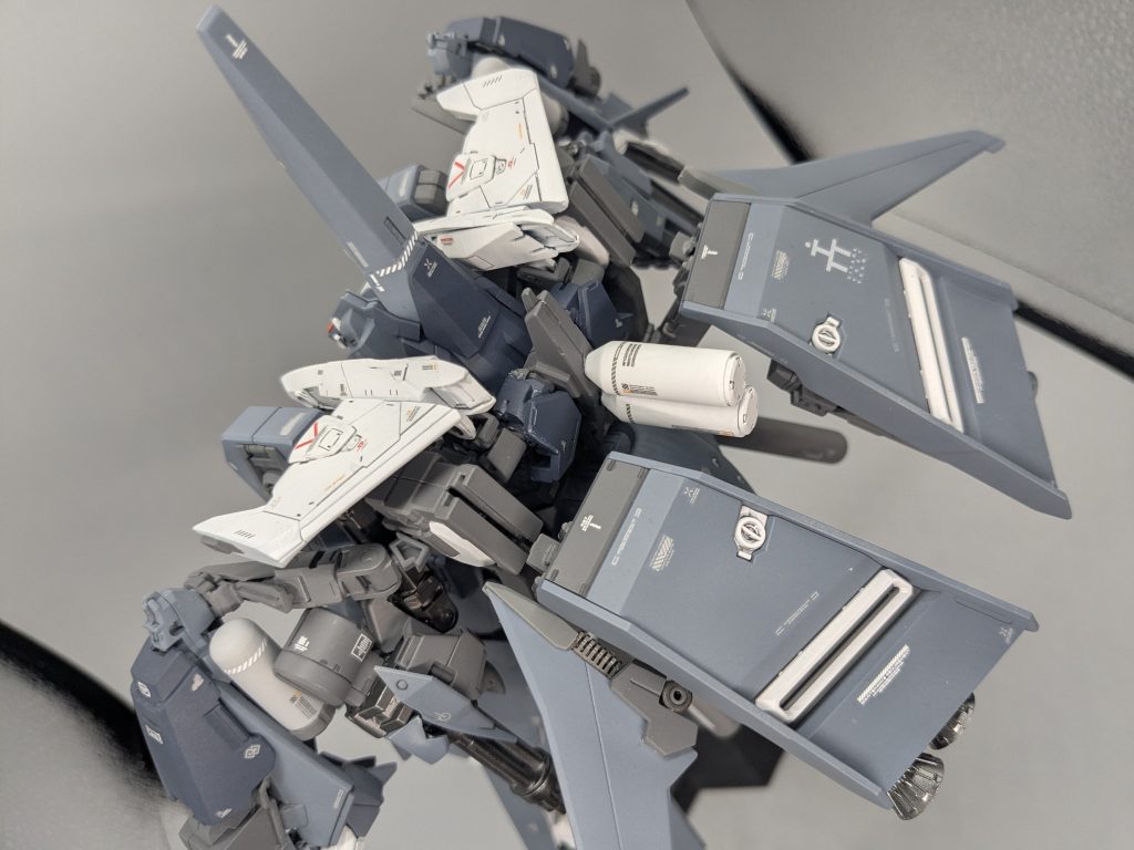 元キットのバインダーをフルドドのアームパーツに接続。ドラムパーツも付属の接続パーツでそのまま活かしてます。機首パーツを切り落とし、ライトニングZのシールドパーツを接合した後、カバーが開いたように接着しました。また、肩のウィングの基部を新造しました。AOZのイカロスユニットをモチーフにプロペラントタンクも追加してあります。