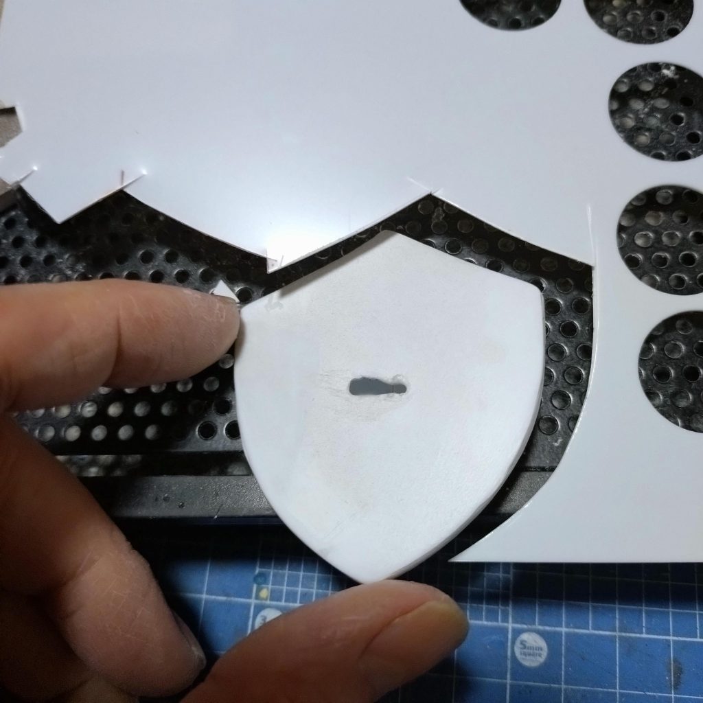 今回制作したのは「騎士ぽくしたい」という事でシールドを新造してみる事にしました。盾からミサイルやニードルが出るとか卑怯な武装なしに騎士らしく剣で戦う「戦士の盾」をイメージしたら、あのゲームの主人公が持つ盾が似合いそうなのでデザインを真似て作ってみることにしました。0・5mmプラ板の積層加工になります。真ん中を膨らました形状が難しく曲げたプラ板を重ねて接着して形にしました。