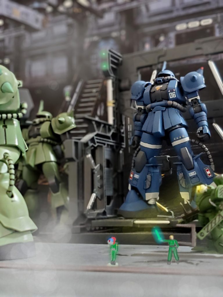 宇宙世紀0079年10月、宇宙要塞ソロモン第8MSハンガー内にソロモン限定生産型高機動型ザクIIが搬入された。それを見上げるパイロットのアンジェリカ曹長🎵このザクは型式番号MS-06R-1E 簡易高機動型とも呼ばれ、バックパックは従来のF型のものを使用している。最大推進出力はR1-A 型には及ばないものの、低コストでの生産と戦闘時の旋回機動性能は十分に確保されている事からドズル中将の認可のもと正式採用となった機体である👍️✨第二次臨時徴兵で採用されたパイロットで構成されたE25エリア防衛MS大隊への高機動型ザクIIタイプの配備は初の事例‼️部隊内は異例の配備に歓喜で満ち溢れていた😆🎵