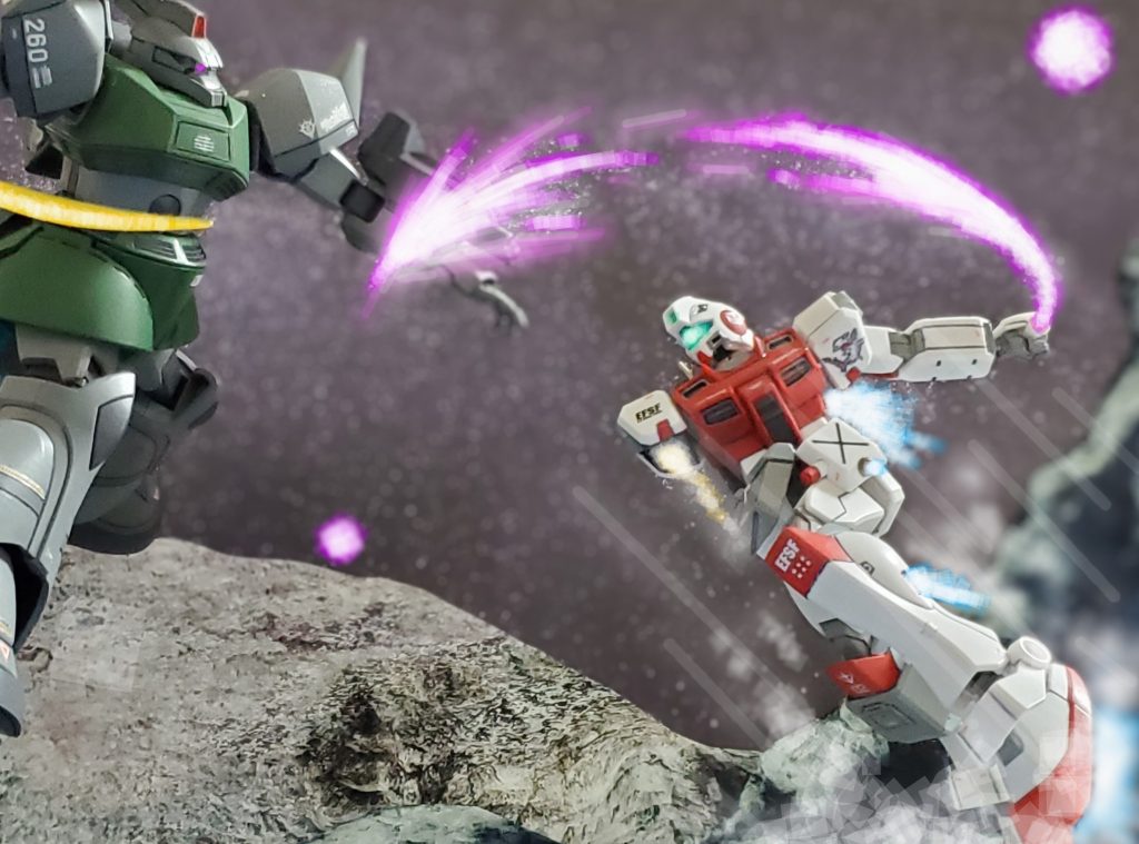 だが次の瞬間❕爆風の中から傷ついたジムタイプが飛び出してきた❗予想外の展開にとっさに左腕の3連ランチャーを構えるがビームサーベルで切り落とされてしまう😱💦どうやらこのジムタイプは増加装甲を身に纏い、右腕は失ったがボディへのダメージはアーマーが受け止めたようだ🤔💦そしてさらに前に出るジムタイプ💨