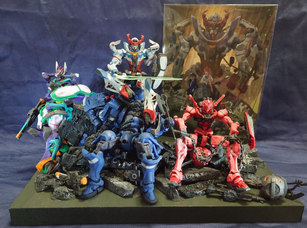 イラスト内のザクヘッドをモビルスーツスケールに合わせて、軍警ザクを山積みにして表現。その周辺のポジションにそれぞれの機体を配置。土台部分や瓦礫などは100均のポリエチレンフォームを使って作成。