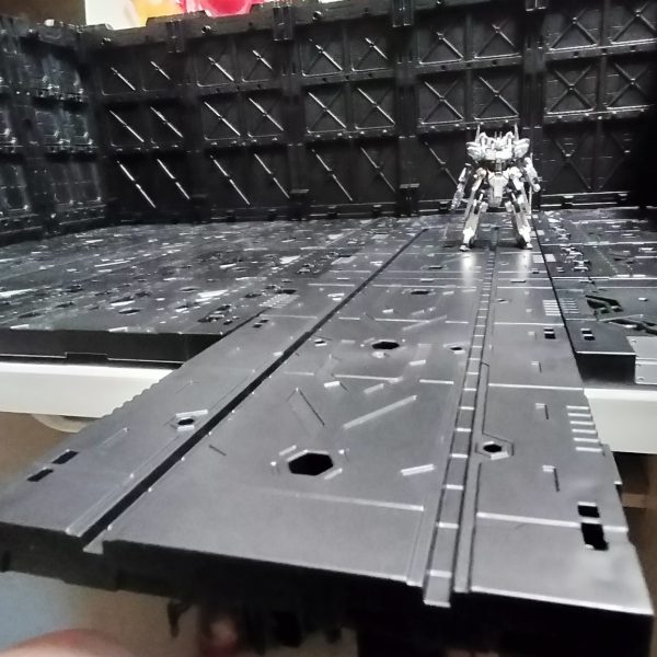 アーティファクトにも強い味方のディスプレイベースなんですが、HG MG 想定で豊富なオプションが構成されていて、飾るものがアーティファクトだとほとんど使えません。格納庫内周辺機材は、アーティファクト用に自作する必要のありそうです。ちょっと遊びで、アーガマの格納庫デッキのようなエレベーターを作ってみました。空母の格納庫からカタパルトデッキへ出撃機を移動させるエレベーターフロアのイメージです。ネオジム接続で支えを設けて、簡単つけ外し対応です。アーティファクトの重さなら、支えられそう。そういえばアーガマのカタパルトデッキって一つのデッキにレール一つでしたよね？　山田化学ディスプレイベースのカタパルトデッキはアーティファクトサイズだと、ひとつのデッキで交互に2機射出できそうです。（6枚目）