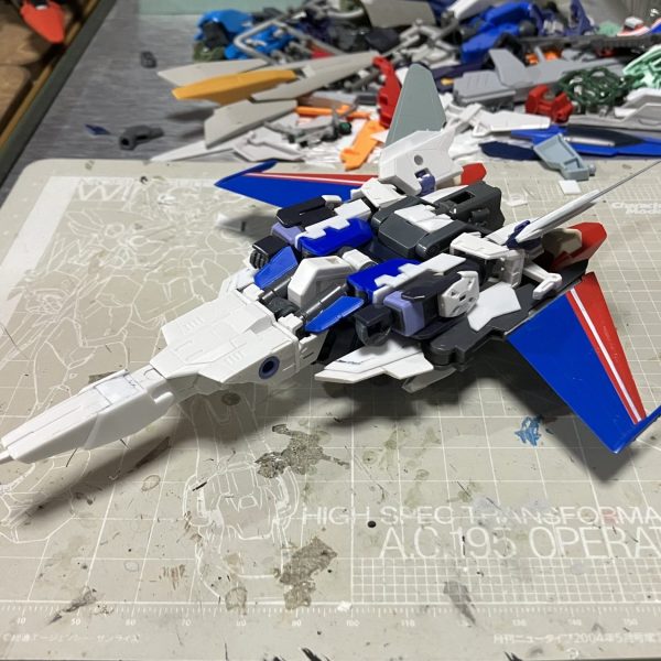 オリジナル完全変形のガンプラを製作しています。新作のファイター形態がやっっっと形になってきました。差し替えなしでMSに変形します。ベースは前作と同じHGクロスボーンガンダムですが今回は肩軸と腰部フレームに可動軸を追加してます。ファイター形態はパーツ構成のバランスにこだわってみました。機首部分と主翼部分との比率や、横から見た時に機首先端より足甲パーツが同じ高さか少し上に配置する等、マクロス作品のバルキリーのデザインを自分なりに解釈して盛り込んでいます。完成はまだまだ先になりそうですが、やっぱり形になると楽しくなりますね。お目汚し失礼いたしました。（1枚目）