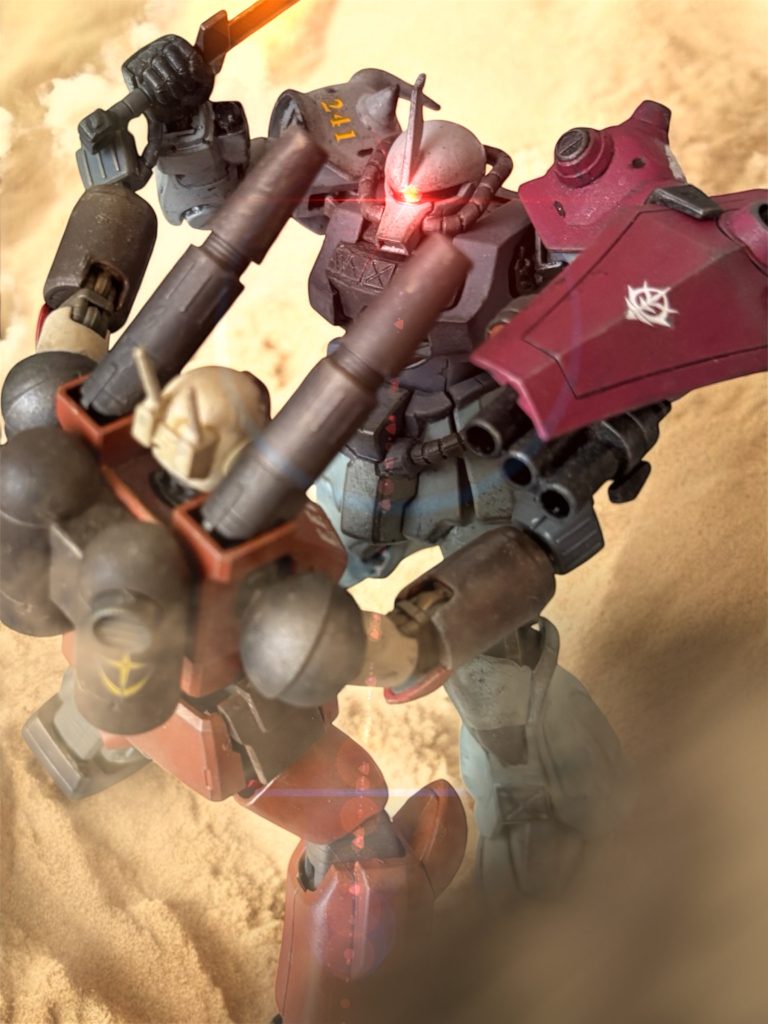 「俺を降ろしたら全速で逃げろ!マイロを頼んだぞ!」行け!と気合を入れた後、ドダイから飛び降りる。敵が、肩に担いだキャノン砲で応戦してきたが、イアンはうまくかわして離脱していく。イアンのおかげで的を絞れない敵機は、アーサーのグフにも着弾させられない。 アーサーは、左腕の35mmガトリングを斉射しながら、一気に敵に詰め寄った。至近弾でも、敵の装甲がガトリングを弾く。やはり、こいつの装甲は”のっぺらぼう”の量産機とは違うらしい。 肩のキャノン砲の射角をギリギリで避け、敵の左下から潜り込むように接近すると、敵は慌てたようにライフルを捨てた。接近されすぎたと判断したのだろう。ライフルも取りまわせまい。サーベルを振りかざした右腕の手首を、締め上げるように押し込んでくる。パワーもある。