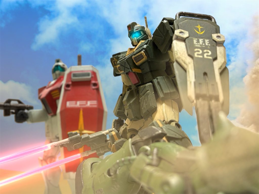 イギー・ドレイク少尉は、サラサール基地の手前で、打って出てきた敵のMS隊を相手に、大太刀回りを演じていた。開けた地形でも、イギーのジムストライカーは、ウェラブルアーマーの性能を遺憾なく発揮し、ビームスピアで文字通り敵を斬り捨てながら進撃した。「例の砂に潜るやつとは、やり合えなかったな。」ある程度、戦線も落ち着いてくると、ふと、そんなことを思った。『ヘント少尉と、ミヤギ曹長の隊が攻撃予定地点に合流していません。もしかすると、そいつらの襲撃を受けているのかもしれませんね。』2番機の軍曹が言うのを聞いて、少し心配になった。ミヤギのガンキャノンは、ここまでの戦いで十分目立つ戦いをした。敵も一つの具体的な目標として捉えるだろうことは予想できた。砂に潜れる連中は、恐らく敵のエース部隊だ。であれば、ミヤギの元に差し向けられることはあり得る。(おまけに、ヘントは色ボケ気味だ。判断を鈍らせなけりゃあいいんだがな。) だが、今のイギーには目の前の戦場に集中するしかない。『敵に、2機ほど手強いのがいます。増援の要請です。』僚機から、更に通信が入る。イギーは、一度ヘントたちのことを思考の片隅に追いやると、伝えられた座標への転進を隊に命じた。■■■■■■■■■■■■■■■