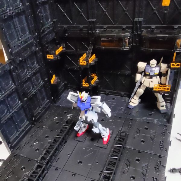 いろんな組み合わせが楽しめるディスプレイベース。今回は地球圏で作戦行動する艦船の格納庫から繋がるカタパルトデッキをイメージしてみました。両脇の整備デッキからそれぞれに真ん中のカタパルトに歩いて移動し、順次射出のイメージです。キャストは昔次男が作っていた素組みさんたち、です。カタパルト横には巻き込み事故防止にガードレールをを付けていますが、無重力下だと意味ないでしょうね。（1枚目）