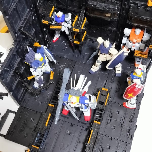 いろんな組み合わせが楽しめるディスプレイベース。今回は地球圏で作戦行動する艦船の格納庫から繋がるカタパルトデッキをイメージしてみました。両脇の整備デッキからそれぞれに真ん中のカタパルトに歩いて移動し、順次射出のイメージです。キャストは昔次男が作っていた素組みさんたち、です。カタパルト横には巻き込み事故防止にガードレールをを付けていますが、無重力下だと意味ないでしょうね。（5枚目）