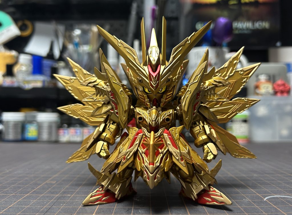 完成作品。比較しづらいかもしれませんが…↓備忘録なので興味ございましたら…長いです。・肩接続を見直すことで肩と頭部の間に隙間作ってます。頭が振れるようになります。ハの字スタイルが軽減されます。同じポーズ自分で取ってみてください。めちゃくちゃダサいです。・股関節作り直してます。フロントアーマーの外側までアンクルガードが開けるように。前後に角度もつけられます。フロントアーマーとリアアーマーの位置もそれぞれ前後1.5ミリづつ厚み増やしてサイドアーマーとぶつからないようにしてます。・ボールデンアームズで肘関節作ってます。ちょっと長めに作ることで少しどっしりした印象になります。肘を引くとポーズが引き締まります。寝太郎23の作例を参考にしています。・翼、バックパック？を幅増ししてます。爪ディテール一個分くらい。前側から見た時の翼の広がりが少し大きく見えます。せっかくの細かい造形、塗り分けを隠しちゃうのもったいないですよね。本家スペリオルドラゴンも大きいですよね？そのものをいじるのはちょっと無理あるなぁと思ったので見える範囲を大きくして誤魔化してます。・融合するために発生する合わせ目。全部消してます。合わせ目にプラペーパー0.1ミリまたは0.2ミリを挟んで軽く瞬着塗って削る、サフを吹いてできてるかチェック、を出来るまで繰り返す。・頭部はさすがにそのまま合わせ目消すと後の塗り分けがキツくなるので分割位置変更してます。縦分割から横分割へ。・全体的にシャープ化してます。リアルタイプはエッジにむかってヤスリかけて尖らせたりしますがそれだけではなくSDではパーツの厚みを取ることが重要ではないかと思います。・脚の肉抜きうめ。大腿部にあるボールジョイントの肉抜きはパテ埋めですが、膝から下の肉抜きはもう一個同じキットを貼り合わせて埋めてます。右脚＋左脚、左脚側の接続軸を切り飛ばして左右均等にノコギリでカットあとは合わせ目消しの要領。同じキットをもう一個使うメリットはいろいろあって、肩アーマーの後ろ側にも前側と同じパーツ付けられるようになってて単純な肉抜き埋めはキツいので前側のパーツを後ろ側に付ける。とか、一部を切り取って尻尾のエンドを作るとか。・ハンドパーツはビルドハンズ。平手はパテで肉抜き埋めてます。・胸フレーム、肩関節の手前にプラ板貼って接続軸丸見えを軽減してます。・腕の合わせ目。メンテ用に放置してます。消すと破損した際一からやり直しはちょっと…・尻尾の肉抜き埋めるのは骨折れました。一箇所につき4回は修正繰り返してなんとか。こんなとこでしょうか。