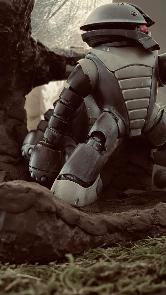 HGアッガイ二体を使用しています。以前の投稿でも使用した密林地帯のベース上にメガハウスのGストラクチャー「ジャブローに散る」を置いています。レッドブラウンで着色後、粘土他で凹凸をつけています。背景には箱庭技研さんの「洞窟」を使用。