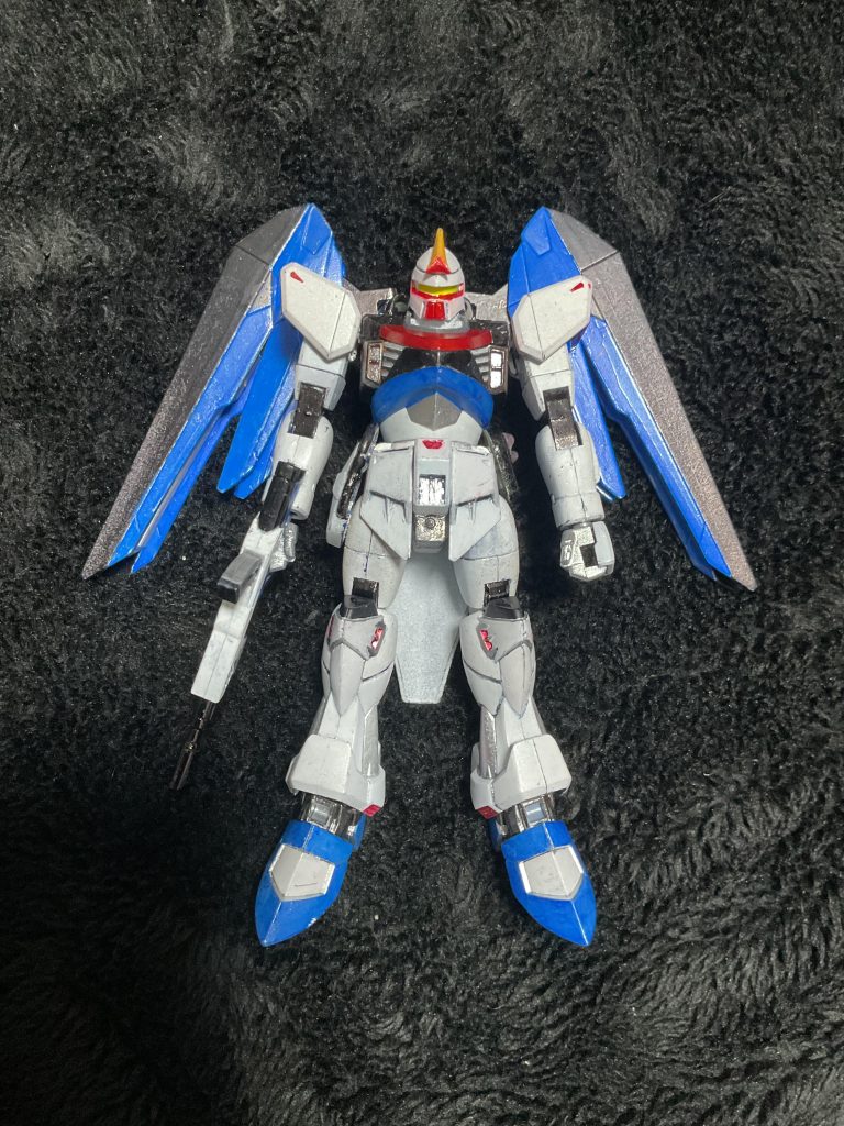前面において特徴はモノアイでない事が大きいだろう。カモフラージュしなければならない機体はモノアイではないがここを似せるには時間がなかったため、なんとか隠す事には成功した。本来のシグーと比べるとパーツはシンプルである。これは、実験用である事が要因である。また、腰はエネルギーパックとビームサーベルを一本装備、ビーム兵器に対応した。シンプルで軽装なのは逃げ足の速さを確保する為。