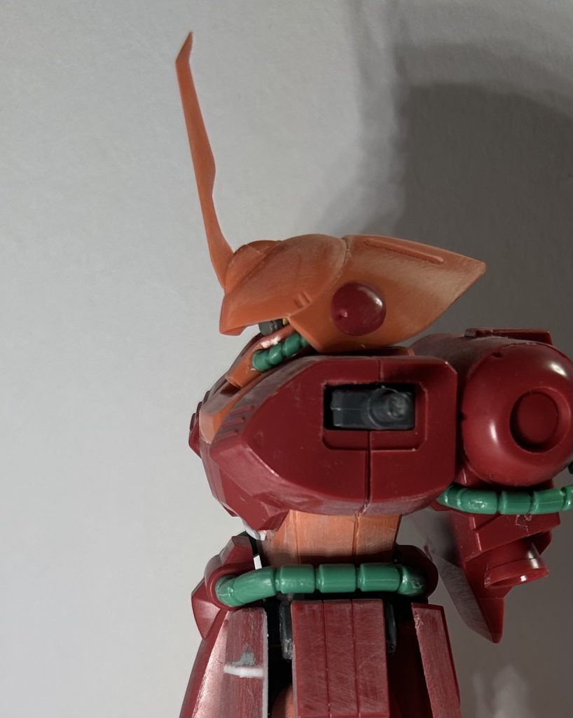 頭部。モノアイレールが入る場所をくり抜いて、そこに軸刺して、プラパイプを刺しただけ……、それで稼働モノアイにしました。ヘルメットの後頭部の形状が好みじゃないんで、カッター等で形状変更。微妙すぎて分からない…！一応キットでは後頭部から錣状のネックプレートが結構なだらかなラインで繋がってましたが…。後頭部を少しけがいてラインを調整、追加パーツっぽいアトモスフィアに……なってたらイイなぁ。胴体。胸部と首元の段差が気になったので、胸部前面を3つに切断し、真ん中を１ミリ底上げしてツラを合わせています。肩との接続部の上面と中のポリキャップを削って、微妙に怒肩が出来るようにしました。思ったよりも効果は無かったけど、少し上げることが出来るようになっただけでも効果は出ていると思います。あと、腰との繋ぎ目、お腹側にプラ板貼って胴長に。ついでにお腹の段差が妙に小さく見えたので、１ミリプラ板で下に段差を延長。