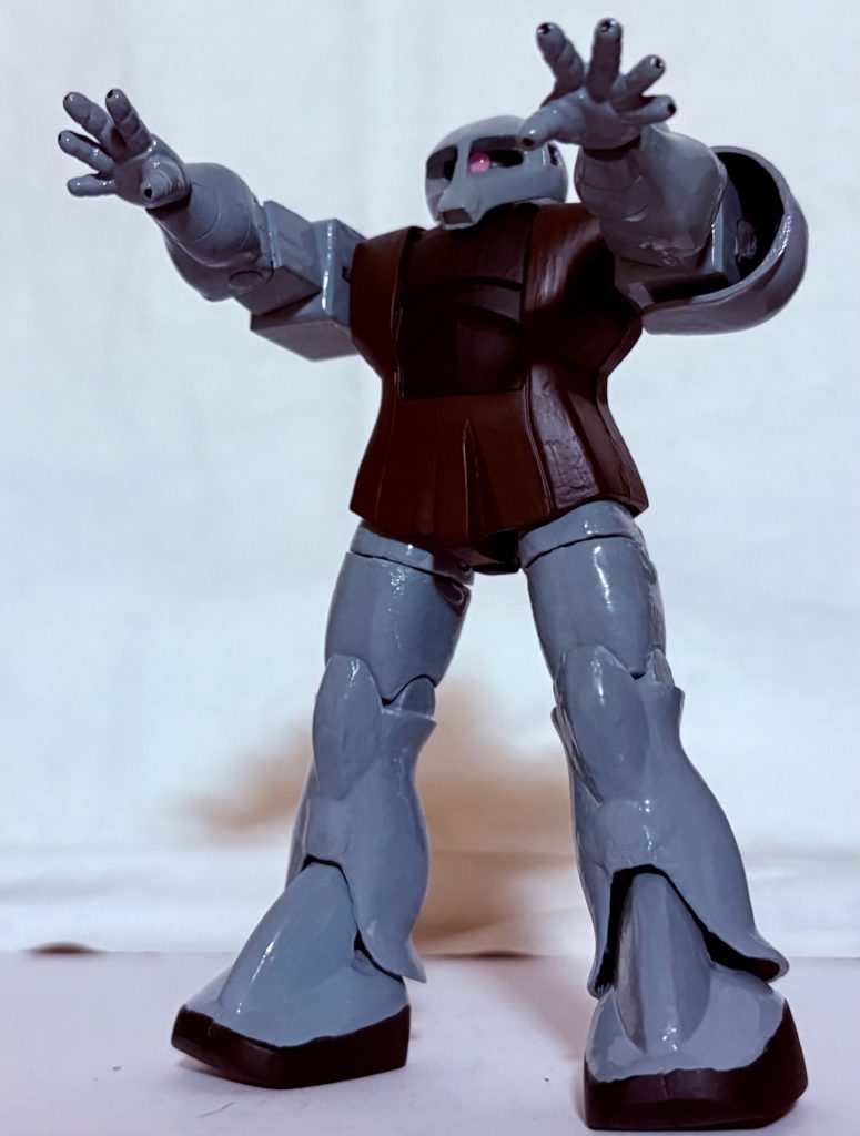 レーザー核融合炉とジェネレーターは新型のモノが使われ、外見こそ旧ザクだが中身は全くの別物と化していた。新型レーザー核融合炉のおかげでビーム兵器も両指に内蔵されており、ジオングのようにメガ粒子砲を発射できるようになった。ただし、エネルギーを消耗しやすいのが難点である。一応火力は調整でき、最小の火力ならレーザートーチとしてコロニー建設やスペースデブリの除去などの作業に応用できる。UC0081年頃から開発が進められていたが、ある事件で消失し行方不明となっていたが、UC0085年頃に突如クランバトルに出現し、ダークホース的な快進撃を続けていた。パイロットはフミオ・タナカという中年男性。ニュータイプではないがなぜかこの旧ザクを乗りこなしており、周囲からは「落としのナカさん」の異名を持って恐れられていた。