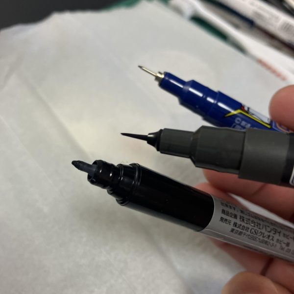 ミスターホビーの極細筆ペン、スミ入れマーカーですね、こんなのあったとは🥰筆ペンのスミ入れバージョンですね✒️ 先が細くて使い勝手が良さそう🥳とりあえず軍警ザクのアックス、パイプ部分のロイヤルメタレッドに投入🥴　スミ入れなので少し下地が透けるのが良い感じ🥳3種比較、どのスミ入れペンで行こうか❓と考えるのも楽しい😋（3枚目）