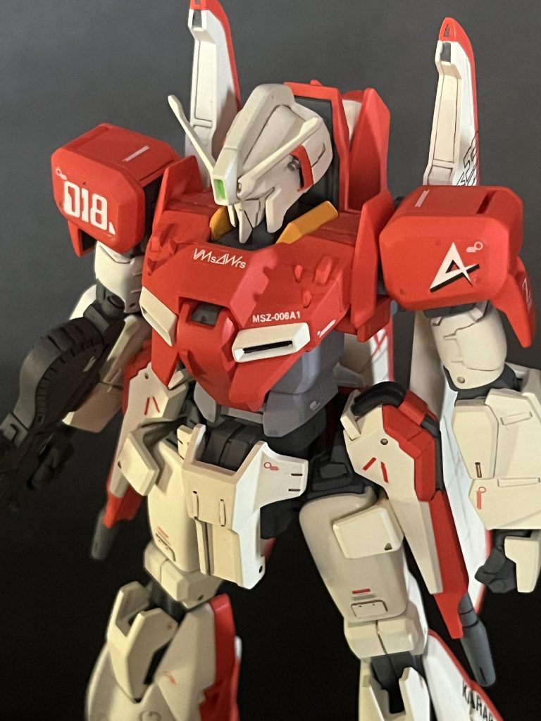 頭部後ろのディテールを再現。胸上面のアンテナを0.3ミリのプラ板で。実寸は長さ1ミリ程度のサイズなので何度も無くしました。中央のコクピットカバーの上部を欠いてディテールを。上に伸びるシールドや背中のウイング、長いライフルにゼータ系の末広がりな脚部など、ちょっと散漫になる視線を機体の中心に持ってくるポイントになるので個人的にはかなりオススメだと思っています。