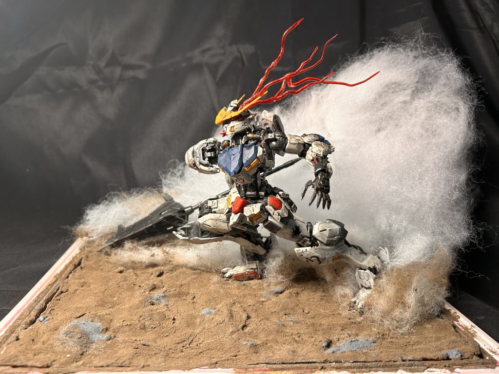 横から地面はタミヤのウェザリングペーストのダークアース、石はタミヤのダークシーグレーを使いました。砂煙を表す綿は撮影する度に「迫力がないな…」と継ぎ足していきこの大きさに。美少女プラモのパテ盛りも同じような感覚に陥るのでしょうか。