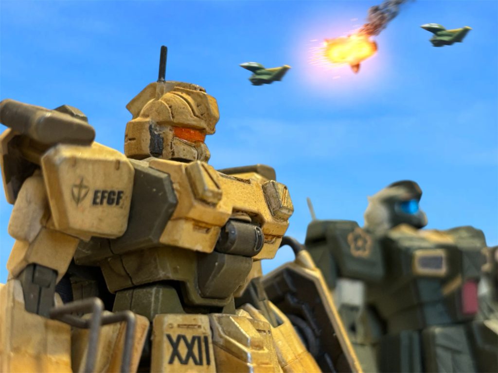 『くそ、羽虫如きにいいように!』 対空装備を持たないイギー・ドレイク少尉は、コクピット内で歯噛みしていた。ヘント・ミューラー少尉とイギー少尉は旅団の中段にいた。空爆と、前衛の砲撃戦を終えた後の、斬り込みを担当する予定だったのだ。 “ライオンズ“とビッグトレーは後衛にいる。後衛からの砲撃が、頭上に炸裂し、ドップが3機ほど、火を吹いて錐揉み状に落ちていくのが見えた。「前衛の掩護に上がろう。ガンタンク隊の被害は戦略的にもダメージが大きい。」『了解。』返事の後、イギーは付近にいたジムの部隊から、自分とヘントに3機ずつ随伴を命じる。「乱戦になっていることが予想されるが、おそらく数はこちらの方が多いはずだ。敵機と一対一にならないように、落ち着いて対処しろ。」随伴する機に命じ、最大戦速で”マスタング”を走らせた。■■■■■■■■■■■■■■■