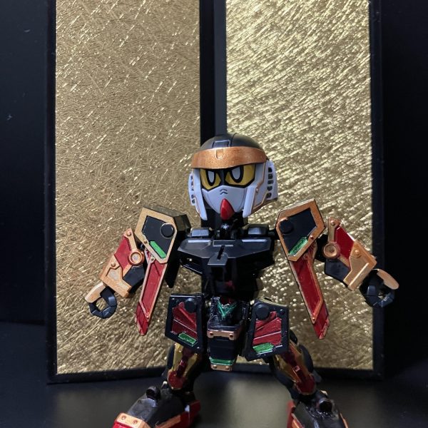 ガンダムマーカー塗装で、一通り完成しています。首と腰が細すぎなので、もう少し横に幅増しするのと、足底の改良などを予定しています。軽装状態でも手を加える予定です。軽装の頭部はSDWHのBUGの頭部を移植してます。元の武者頑駄無リスペクトで、金色の鉢金を付けているようにしています。パケ絵とは緑が足りませんが、ちょっと余計かなあと、塗ってません。背景にあるのは、やっと見つけたセリアの金屏風。もう1つ欲しい。（5枚目）