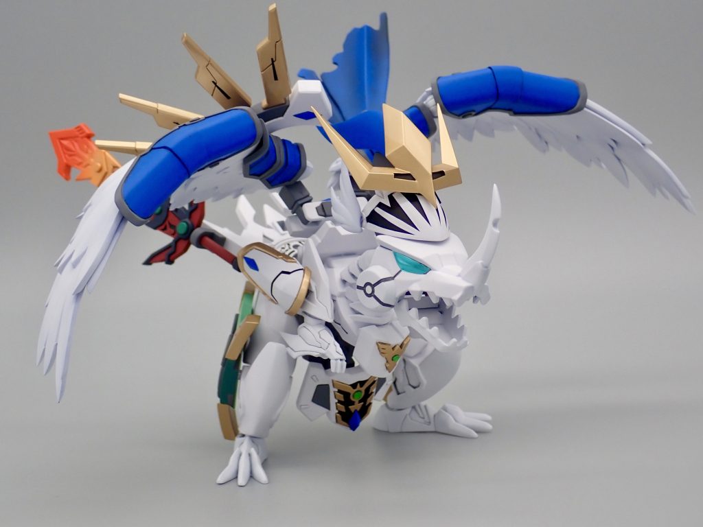 ネオフェザードラゴン、ラクロア第二位の精霊である光のフェザードラゴンが一時的に古の神器の力を継承した姿。力の継承が不完全だったため、出所不明の神器や、左右非対称な翼を持つ。 シャイングラスパードラゴンをベースに超将軍闘我、アルカナディア「ルミティア」や3Dプリンター出力品の部品を組み合わせて制作しました。原典のフェザードラゴンがそうである様に、基本的にはトールギス用の鎧を保持するサポートメカとしてデザインしています。三種の神器をウイングの世界観や、SDガンダムフォースに登場する魔剣エピオンなどと組み合わせて独自にデザインしています。