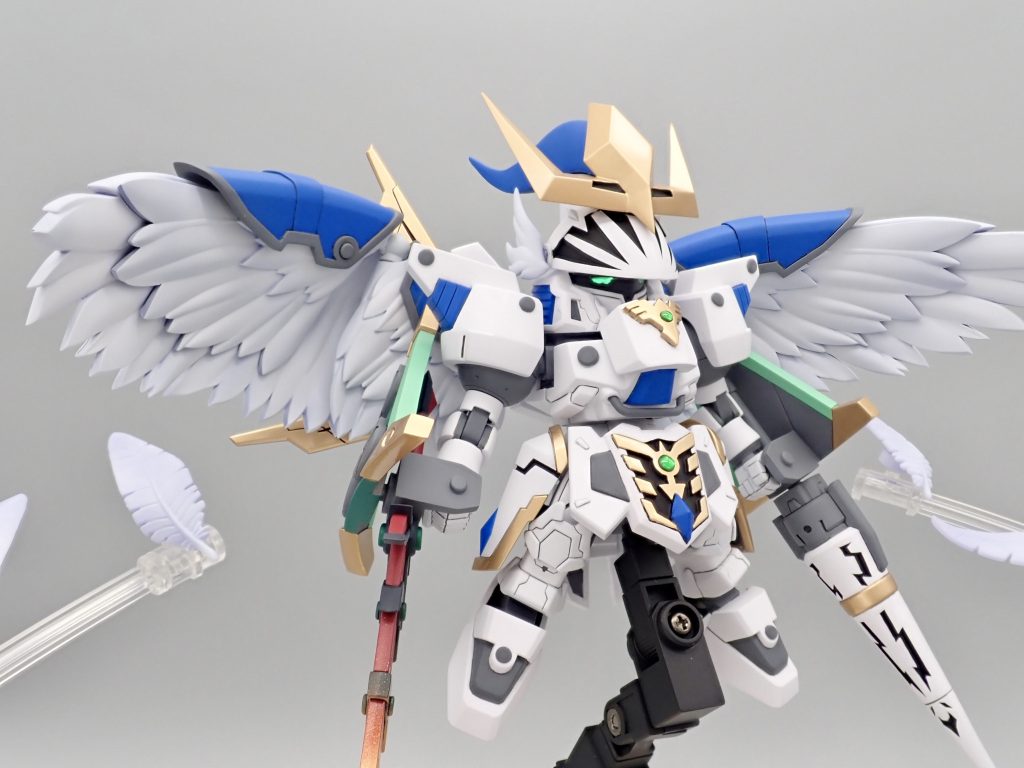 今作のモチーフは神聖騎士ウイングをメインに据え、雷迅機トールギスの意匠を取り入れて制作しています。フェザードラゴンが三種の神器を不完全な形で継承した想定で、炎の魔剣エピオン、霞の幻翼セラフィム、力の障壁プラネイトを配置し、新たな神器として嵐の裂槍テンペストを加えています。