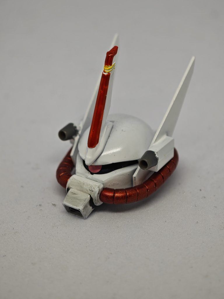 頭部にはオプションパーツのユニットアンテナを接着。両サイドにはプラ板とプラ棒でサイドアンテナとバルカンを作りました。ザクⅢに似せつつバルカンはオリジナルです。