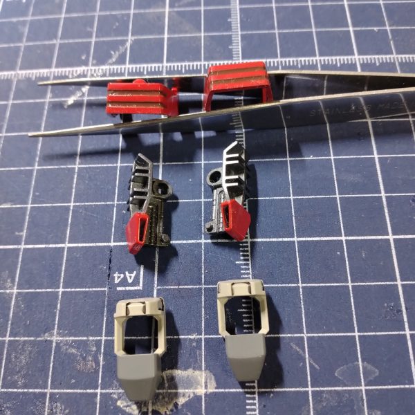 アンクルガードの横に掘られたの溝が特徴の脚部です。ヘビーガンダムは足だけ取り出すと、実にかっこいいのですが、本体に組み込むと膝より下が細く、またアンクルガードが小さいので、ヘビー感が薄いのです。膝のバーニヤ、膝の裏、腿、アンクルガード、足の甲、つま先などを細々と塗り分けました。右足の大腿部に貼った赤ラインのシールは、傾いていたので後で直しました。（2枚目）