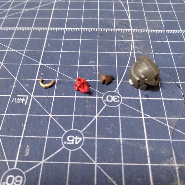 ゴーグル（モノアイ？）が印象的な頭部です。狂四郎のヘビーガンダムはこんな目だっただろうかと疑問を感じますが、自分にはどうしようもないので仕方ない。顔とアゴを後ハメ加工にしてやりました。側面の合わせ目の段差がひどいことになっていました。ランナー跡を削り過ぎたようなので、パテで埋めて修正しました。頭部はメインカラーに選んだマルーンだと色が濃くてパッとしなさそうだったので、色の薄いリノリウム甲板色にしました。ゴーグルはMGらしくなるように、チタンゴールドで塗りました。（3枚目）