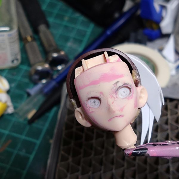 よくよく目的のキャラ画像見ながら目蓋周りの形をランナーくずと流し込み接着剤で少し変えてます。表面と形確かめるためにピンクサフ筆塗りしたりヤスったり、まつ毛ライン描いてみたりヤスったり。口周りも少し変更、輪郭も少しシャープにしてみてます。眼球パーツが中に入り過ぎなのでプラ板貼って厚み出し中です。硬化後顔パーツに合わせながら少しずつ修正かけます。Netflixで確認してみたら髪型の後側ばっちり出てたのでこれも今後修正とザックリ作った前髪ももう少し位置関係の調整で多分やり直し…まだまだ先は長そうです。（3枚目）