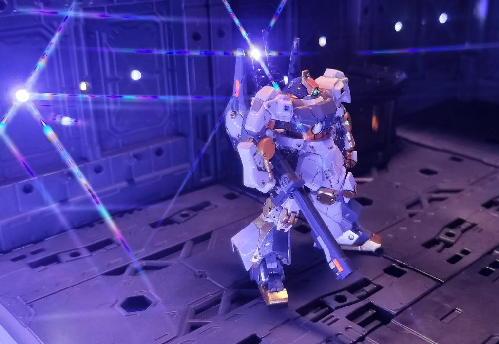 15.        最近山田化学さんの百均ヒミツ基地セット(勝手に命名)を簡易塗装してドリルで穴をあけておきましたので、そこに裏からテープLEDをマスキングテープで貼って簡易電飾、スマホカメラにクロスフィルターをとりつけて、格納庫の中の強めの作業照明的な演出をしてみました。撮影が終わった後は、サーカスの巡業のようにすべて段ボール箱にしまって撤収しています(笑)。