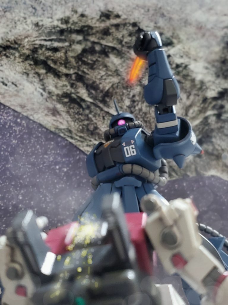 そしてブラッドラインが機能停止に陥っているのを理解したのか、大きくゆっくりと左腕を振り上げトドメと言わんばかりに構える高機動型ザク。これで命が尽きるのか…と悟ったシイコ少尉の身体から怨念のオーラが薄れて消えていく…。彼女の「彼」のいる場所に自分も行きたいという願望が怨念という形で現れ、死に急ぐ危険な戦い方へ誘っていたのであった…❇️『これでやっと「彼」のいる所に逝けるのね…』そう呟き、天を仰ぐシイコの頬を涙が流れていく。『シイコ、大丈夫だ…👨』⚡突如、雷のような光と声が彼女の脳裏を走る。そして、光の中に見えた「彼」の姿❗