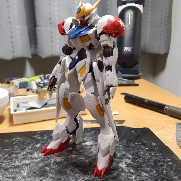 元々長いガンダムフレームの手足が追加パーツで更に長くなったバルバトスルプス。さすがに長過ぎるので足首のボールジョイントで1.7mmほど詰めて背骨を4mmも延長。 模型誌の作例だとプロポーション変更をする際、標準サイズの1/144キットだと脚を2～5mm、胴を1~2mmくらい延長するのが定番で、脚を詰めるというパターンはあまり見ないし、それに加えて胴を4mmも伸ばしたら酷い胴長短足の体型になりそうなものだけど、ここまでいじっても脚長感が維持されている辺り、元がどれだけながいかよくわかりますね。 シリンダーが無いせいもあるけど、背骨を縦に伸ばした分横幅(5mmしかない)が狭く見えるので薄手のプラ板でサンドして太くする事を検討中。（1枚目）