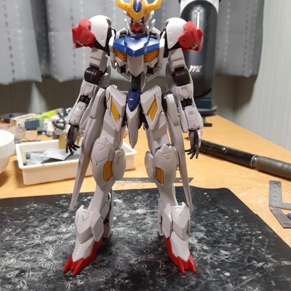 元々長いガンダムフレームの手足が追加パーツで更に長くなったバルバトスルプス。さすがに長過ぎるので足首のボールジョイントで1.7mmほど詰めて背骨を4mmも延長。 模型誌の作例だとプロポーション変更をする際、標準サイズの1/144キットだと脚を2～5mm、胴を1~2mmくらい延長するのが定番で、脚を詰めるというパターンはあまり見ないし、それに加えて胴を4mmも伸ばしたら酷い胴長短足の体型になりそうなものだけど、ここまでいじっても脚長感が維持されている辺り、元がどれだけながいかよくわかりますね。 シリンダーが無いせいもあるけど、背骨を縦に伸ばした分横幅(5mmしかない)が狭く見えるので薄手のプラ板でサンドして太くする事を検討中。（2枚目）