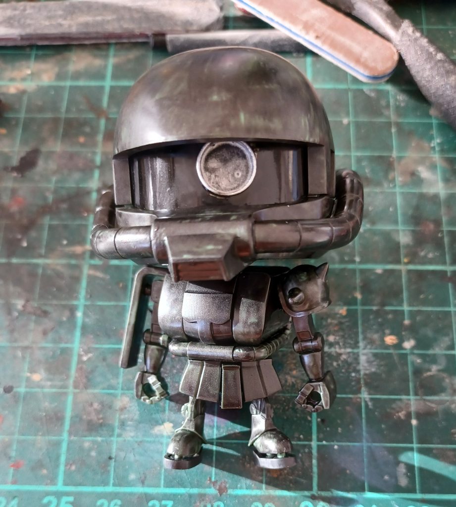 下地塗りだが、あの有名な「メカサフ　ヘヴィ」は持ち合わせていないし、買うつもりもない。清水式では、「メカサフ　ヘヴィ」が推奨されてはいるが、無いものは仕様がない。(買っても良いが、用途が限定されるのでなかなか買えずにいるのが現状なのである)とにかく、濃いグレーで塗れば良いのではと安易な思考のもと、水性ホビーカラーのH32ダークグレーの瓶を手に取って、筆で塗ってみた結果がこの画像のザクプラくんなのだ。