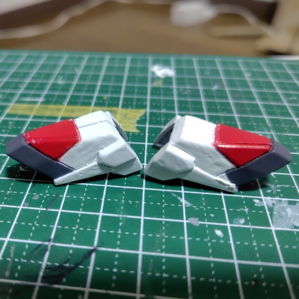 本来シールを貼る箇所なんですが、剥がれるのが嫌なので塗装しました。ガンダムマーカーの直塗り→ガンダムマーカーの筆塗り→はみ出した赤を消しペンで消そうとしたら逆に広がってしまったのでタミヤアクリルカラーのホワイトを筆塗り→厚塗りすぎたので表面を均そうとヤスリがけしたら他の色も剥げてしまったので、マスキングしながら３色改めてガンダムマーカーのエアブラシシステムで塗りました。アクリルカラーは希釈して塗り重ねればよかったと反省。最後にガンダムマーカーのトップコートを吹いていますあ