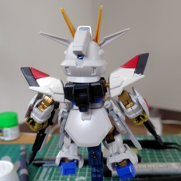 やっとここまで漕ぎ着けました。センサー類とウイングのラインは付属のホイルシールを使用。フロントアーマーに少々カラーアレンジを施しています。ビームライフルのブルーはおもちゃっぽくなるのであえてシールを貼っていません。ライフルはつや消し、それ以外は光沢のトップコートを吹いています。実はこれで完成ではなく、さらに一手間かけます。その前に肩パーツのポロリを改修せねば。（4枚目）