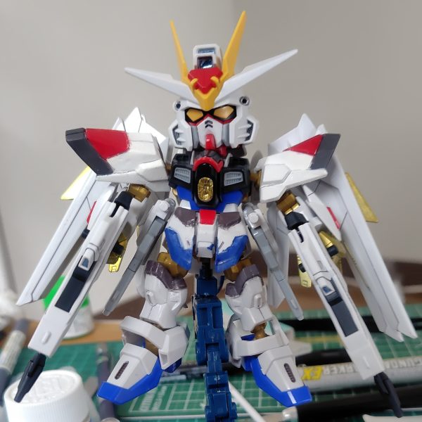 やっとここまで漕ぎ着けました。センサー類とウイングのラインは付属のホイルシールを使用。フロントアーマーに少々カラーアレンジを施しています。ビームライフルのブルーはおもちゃっぽくなるのであえてシールを貼っていません。ライフルはつや消し、それ以外は光沢のトップコートを吹いています。実はこれで完成ではなく、さらに一手間かけます。その前に肩パーツのポロリを改修せねば。（3枚目）