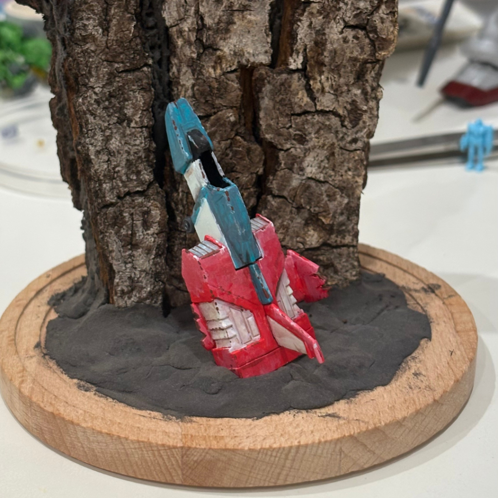 円形の台座に、粘土で地面を作りコアファイターをぶすりと埋め込み。崖は実家に落ちてた朽木を利用。なんの木かもよくわかりませんが、中身をくり抜き、熱湯に入れて防虫処理した後、天日乾燥。自然素材の使い方を少し覚えました。